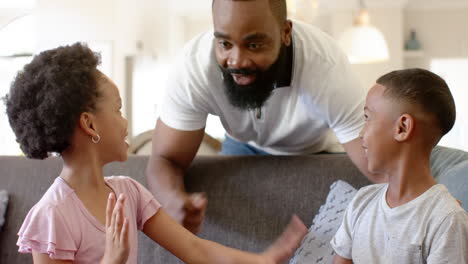 african american father playing with his young son and biracial daughter