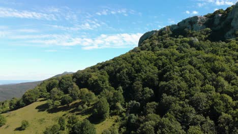 aerial footage of blue sky, white clouds and cliffs over a forest, backwards motion, kotel, bulgaria - october 15th, 2018