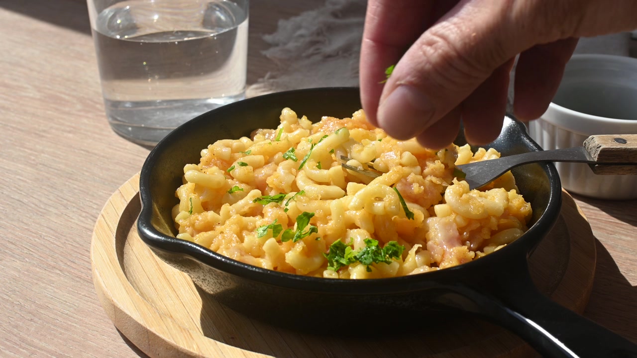 Espolvorear perejil fresco sobre unos cremosos macarrones con queso caseros