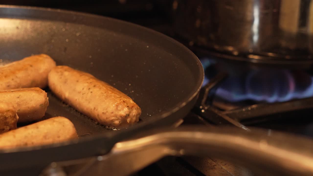 Delicious Meat Alternative Sausages Cooking with Hot Gas Burner in Background