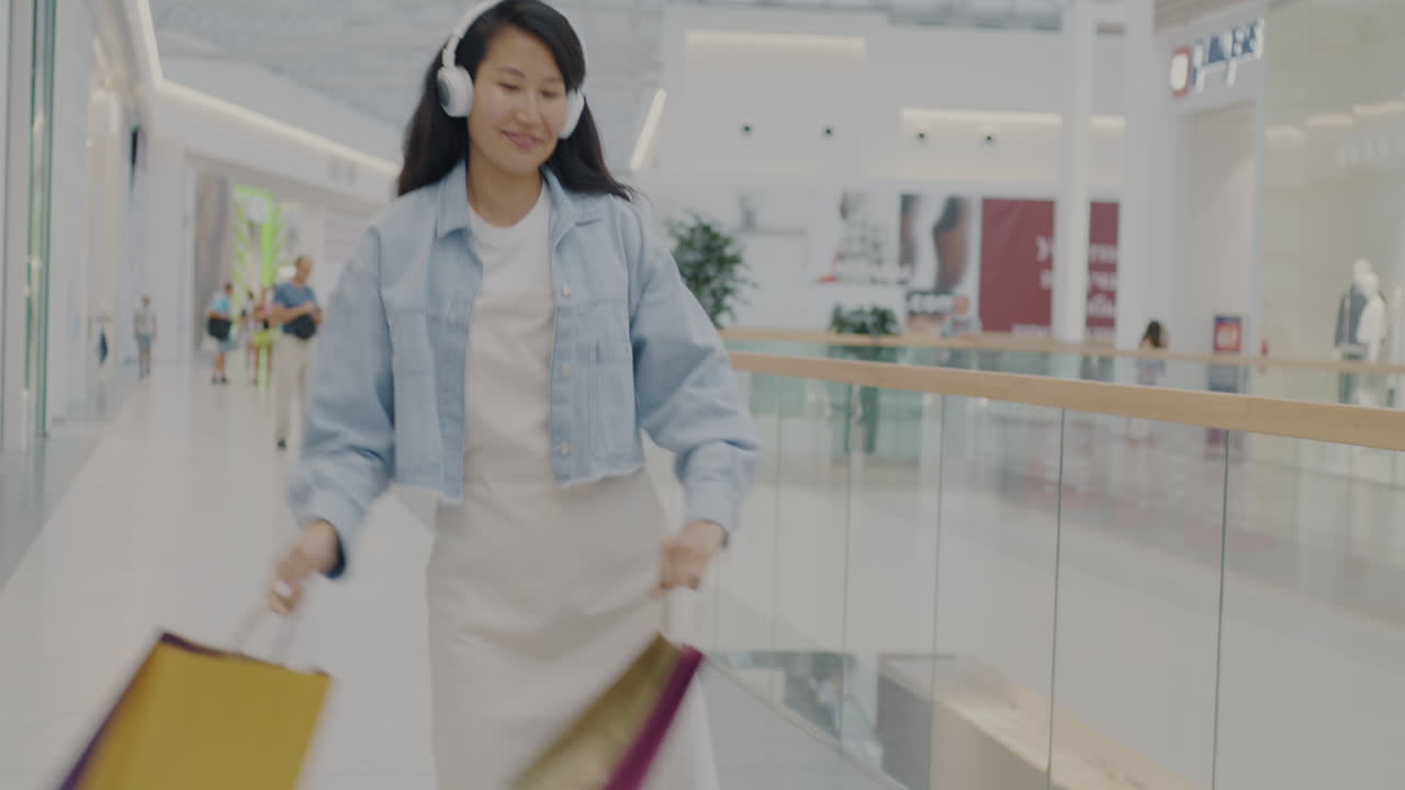 Happy Woman Shopping and Dancing in a Mall