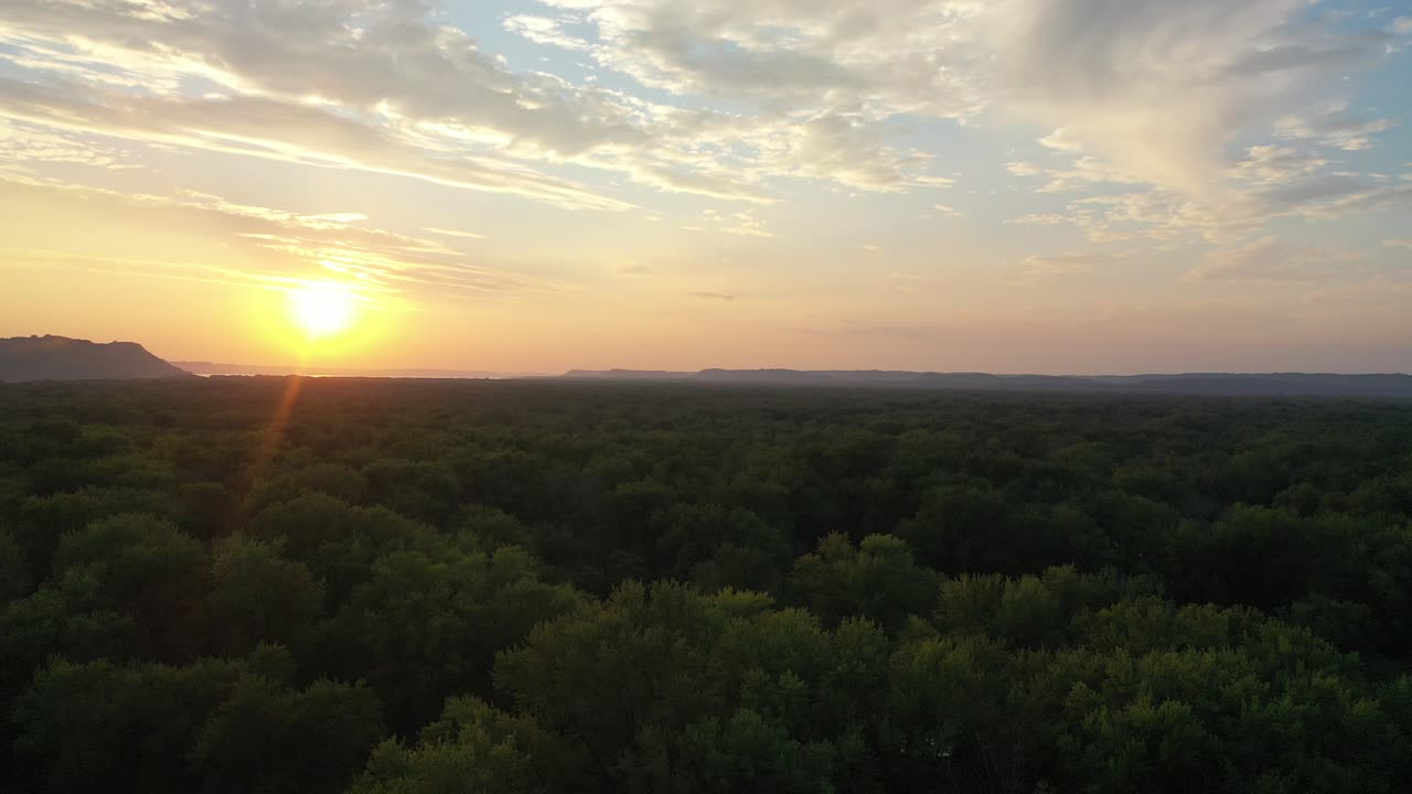 Sunrise or Sunset Over a Forest and River