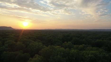 sunrise or sunset over a forest and river