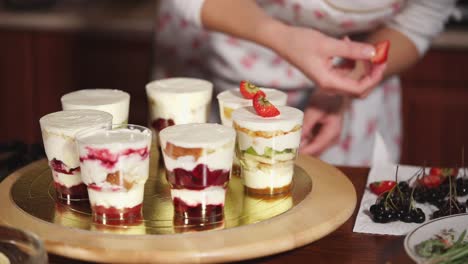 woman preparing layered dessert cups