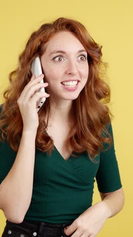 excited redhead woman talking on smartphone