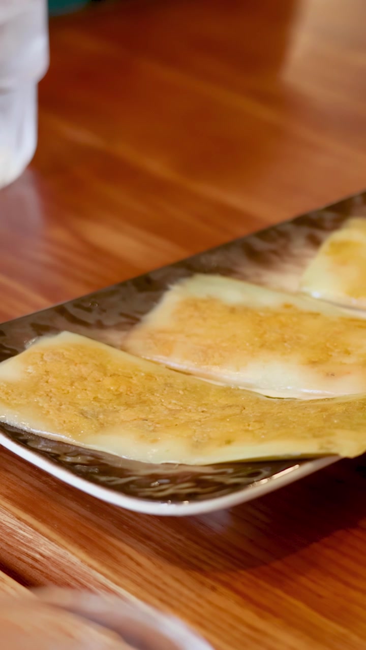 Primo piano di crepes di riso croccanti su un piatto sotto la calda illuminazione interna di un ristorante