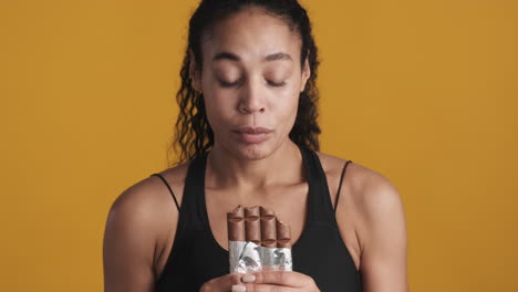 una mujer afroamericana desconcertada sobre un fondo amarillo.