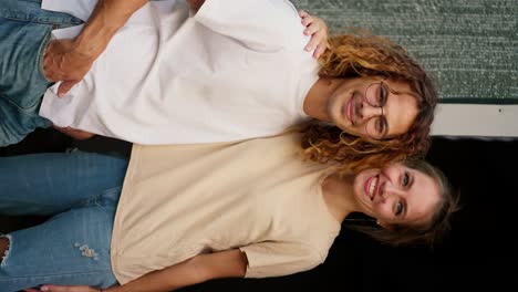 Vertical-portrait-video:-A-girl-in-a-t-shirt-and-jeans-hugs-her-curly-haired-boyfriend-in-glasses.-Rest-in-the-country-house