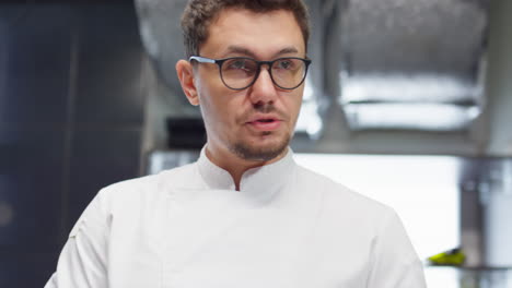 chef taking notes and talking with colleague in restaurant kitchen