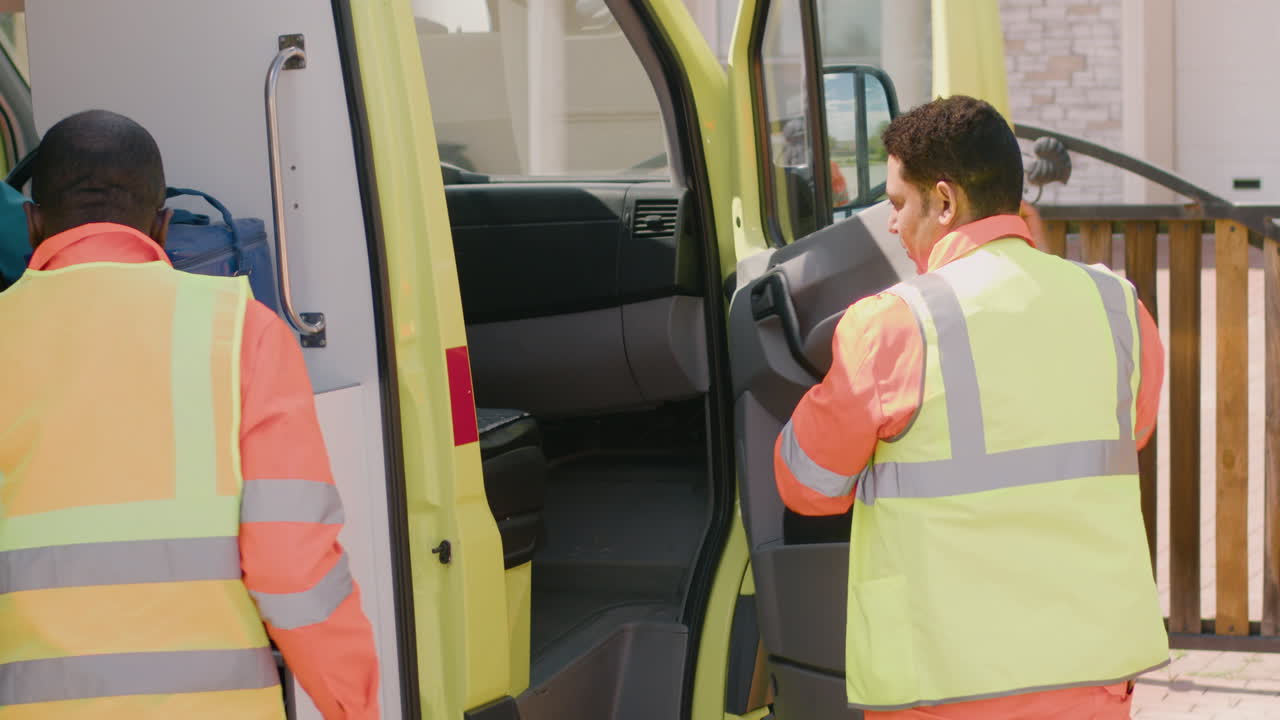 машина скорой помощи подъезжает к дому, где два медработника бегут оказывать помощь больным людям