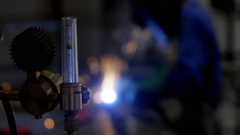 female welder using blowing torch on a rod 4k