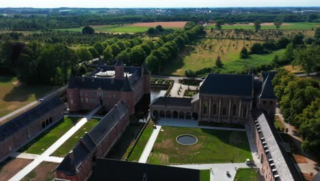 aerial circular view of mansions in alden biesen castle in belgium, germany spread across large area with greenery and landscape during day