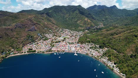 aerial drone footage showcases stunning pitons bay in st. lucia, revealing vibrant city views and lush green hills. the sunny summer day enhances the picturesque scenery of small houses, white boats.
