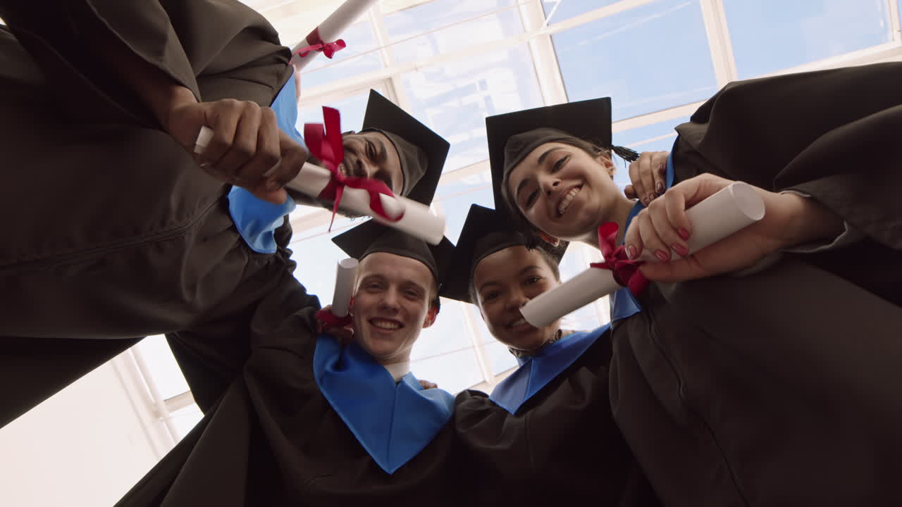 Four Happy Diverse Friends with Diplomas during Graduation