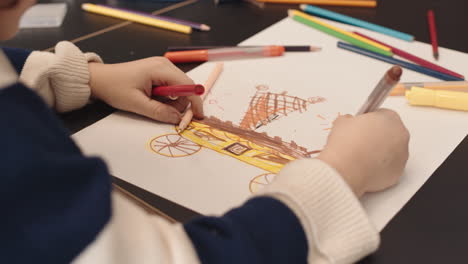 child drawing with markers on paper