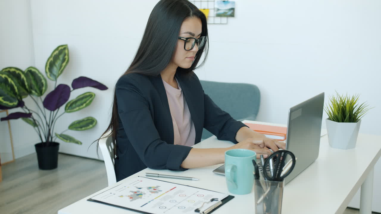 mujer trabajando en una computadora portátil en la oficina