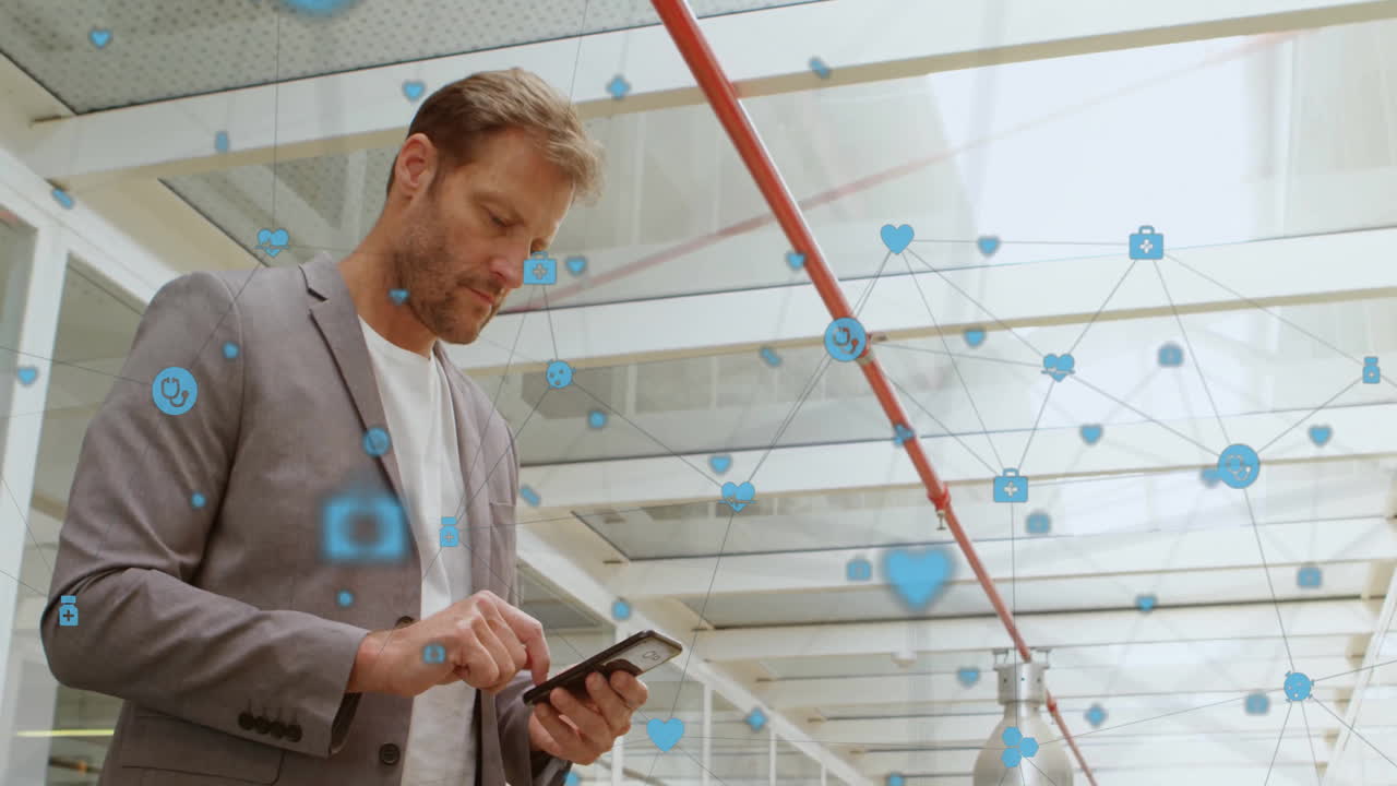 Animation of icons connected with lines over smiling caucasian man standing and using cellphone