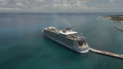 aerial tilt shifts perspective of huge cruiseship moored in bahamas