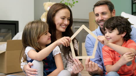 una familia sonriente de cuatro personas estableciéndose en un nuevo lugar