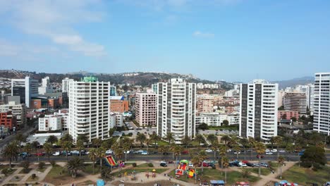 órbita-Aérea-De-Viña-Del-Mar-Edificios-Y-Apartamentos-Turísticos-Cerca-De-La-Orilla-Del-Mar-Y-Avenida-Rodeada-De-Palmeras-Durante-El-Día,-Chile