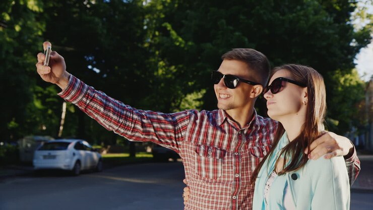 Una coppia innamorata si fa un selfie ai raggi del sole all'aperto. Video HD.