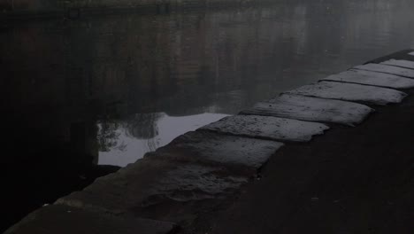 lonely canal pathway at water edge panning shot