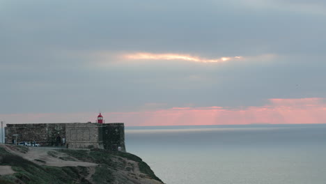 Beautiful-Sunset-By-The-Beach-At-Farol-Da-Nazare-With-View-Of-Lighthouse-In-Praia-Do-Norte,-Portugal