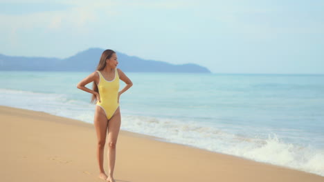 Encantadora-Chica-Asiática-En-Traje-De-Baño-Amarillo-Camina-En-La-Playa