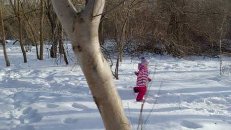 Joyful-little-child-girl-kid-running-towards-on-snowy-road-through-winter-park-forest-outdoors