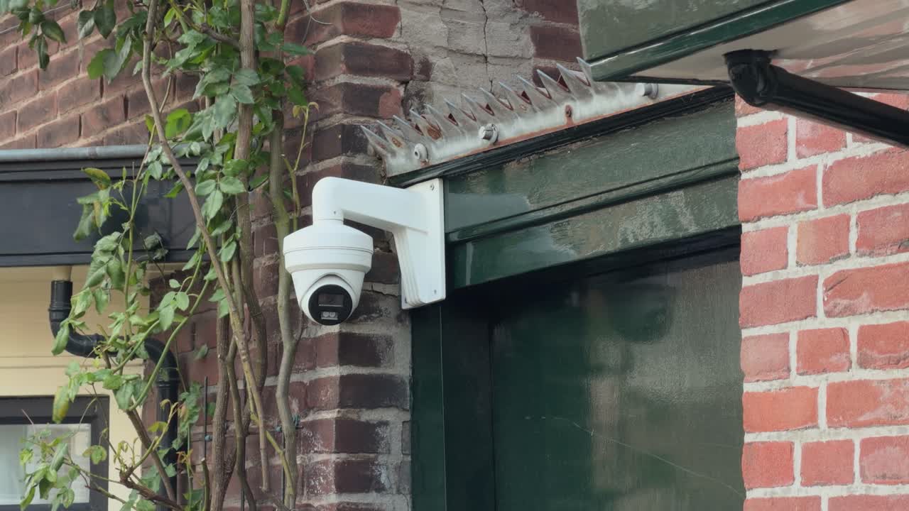 Close-up shot of a mounted outdoor security camera attached to a brick exterior wall