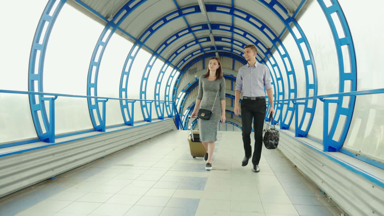 un hombre y una mujer van con equipaje a la terminal de la estación o del aeropuerto