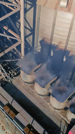 drone view of grain elevator silos. aerial view of silo storage tank for grain food. vertical video