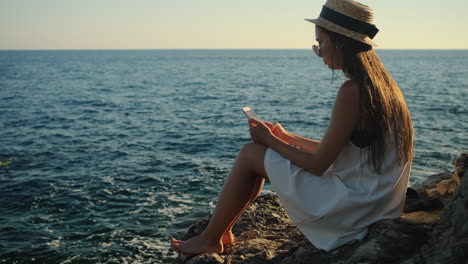 woman with a phone on a cliff