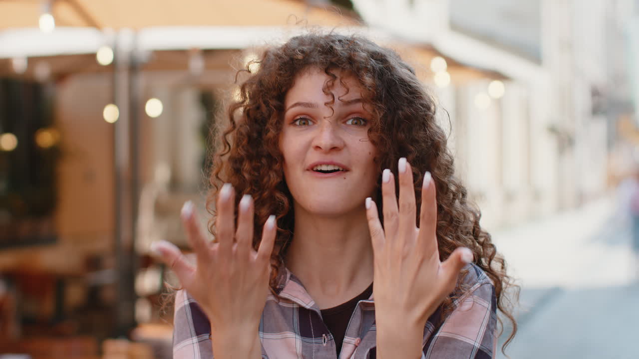 joven mujer mirando sorprendida a la cámara conmocionada por la repentina victoria buenas noticias de victoria wow en la calle de la ciudad