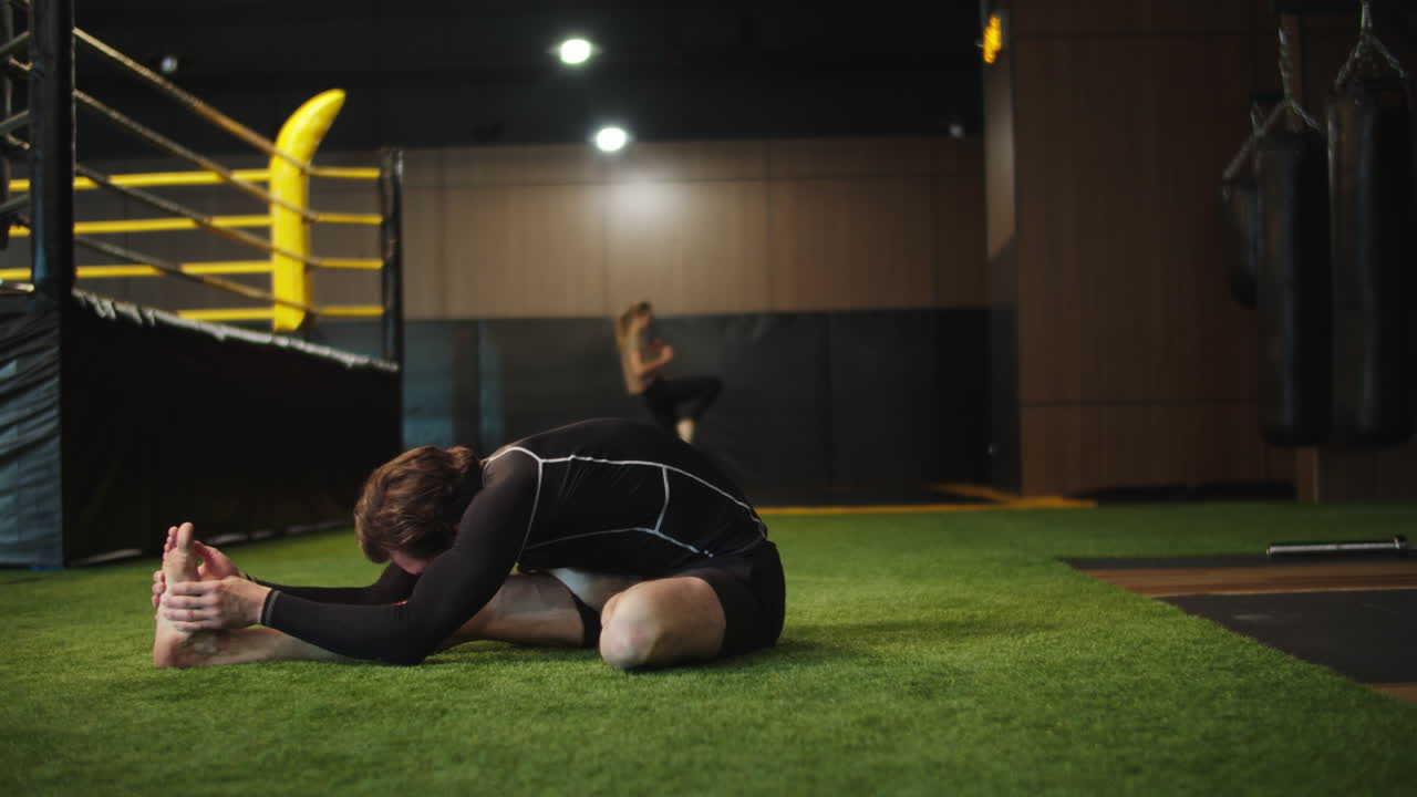 hombre de deporte estricto calentando en el centro de fitness. boxeador masculino ejercitándose en el gimnasio