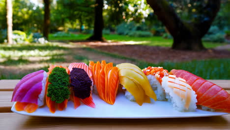 assorted sushi and sashimi on a plate outdoors
