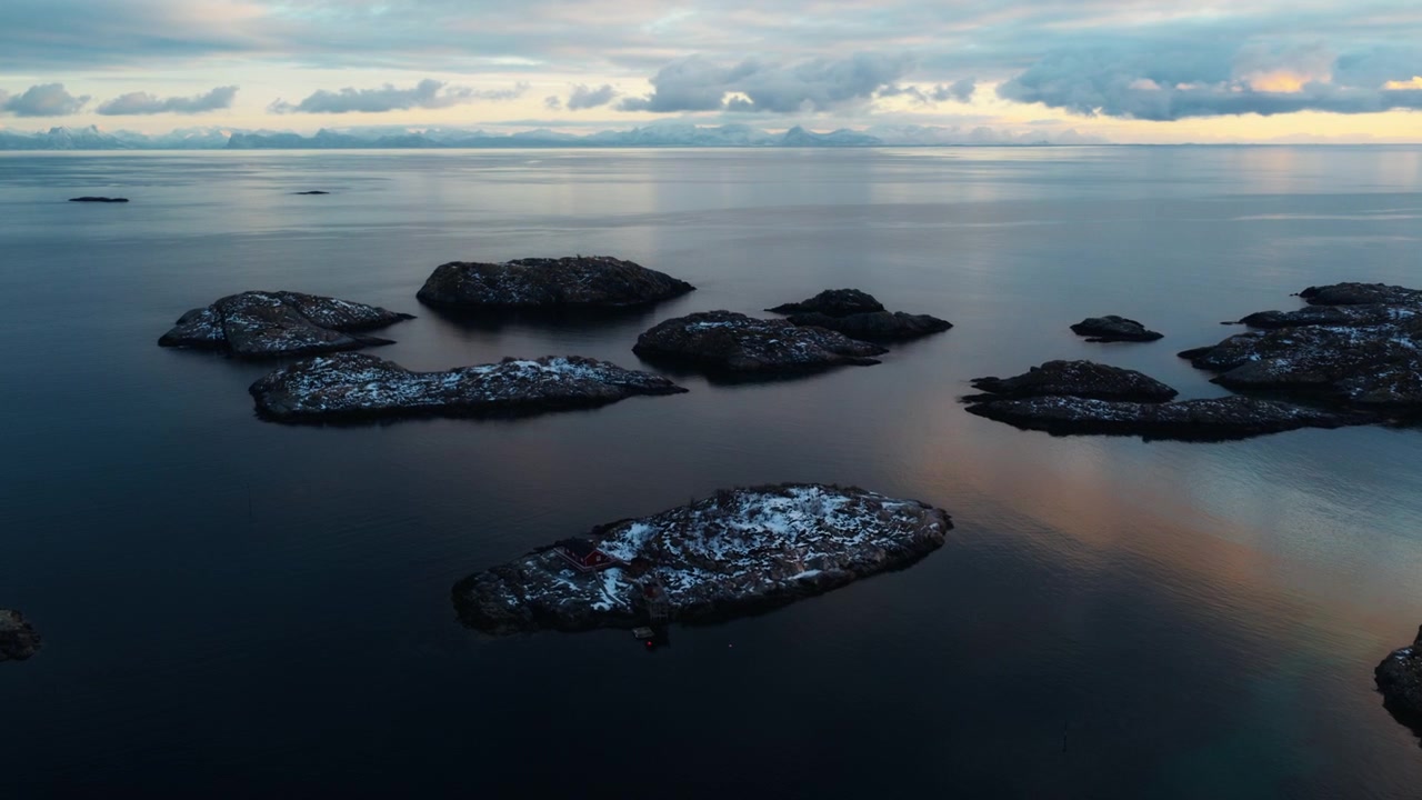 Pulau-pulau Arktik kecil bersalju dikelilingi perairan gelap tenang di Lofoten, drone.