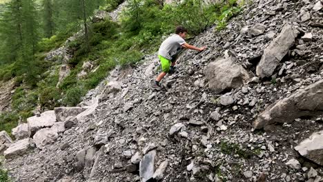 cute young boy doing well while climbing mountain full of rubble