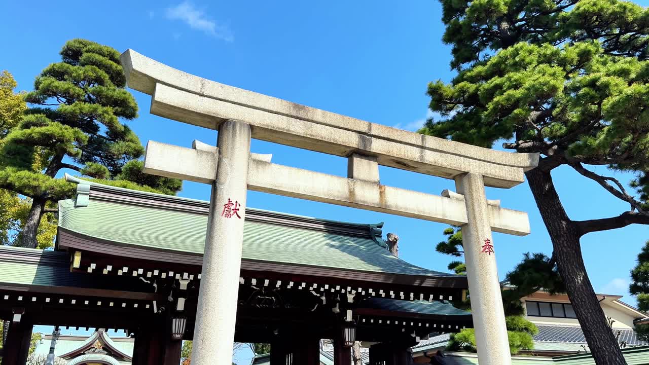 Torii-port ved Rokugo-helligdommen under klar blå himmel, med en fredelig stemning.