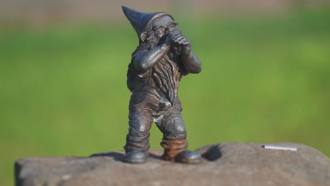 a metal statue of a gnome in the garden