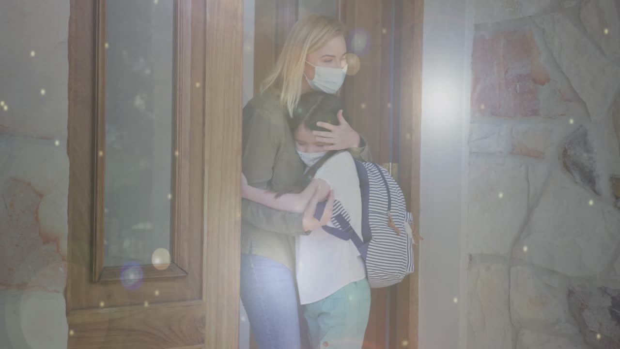 animación de puntos de luz sobre la mujer caucásica y su hija con máscaras faciales abrazando