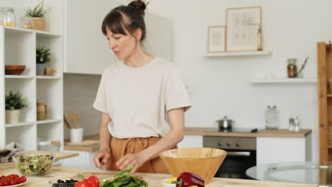 Young-Woman-Cooking-Salad-in-Kitchen