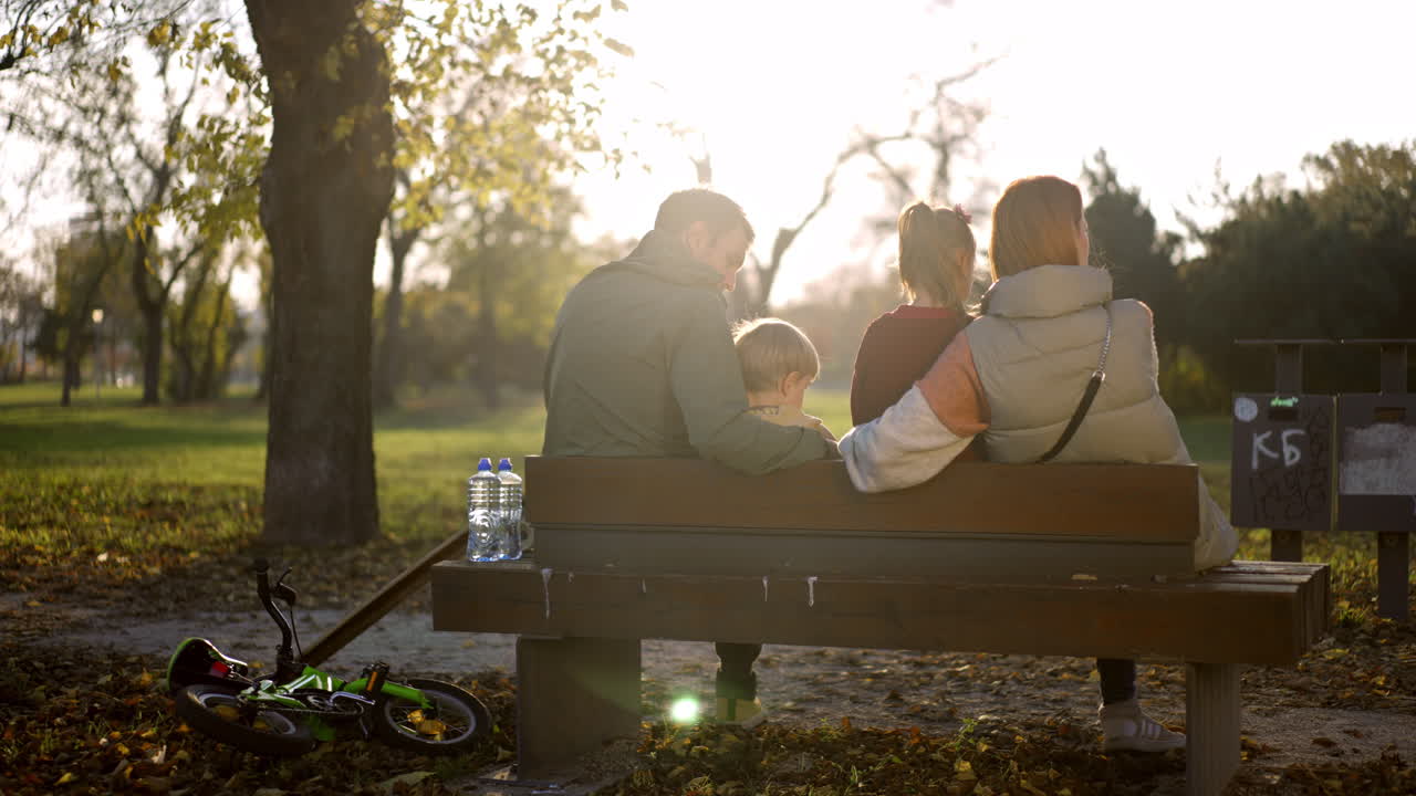 Family relaxing on a bench in the park