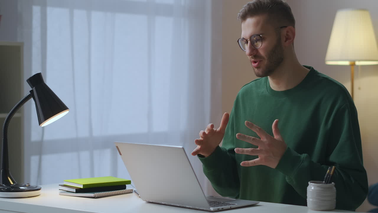 adult man is greeting colleagues and partners at online meeting speaking and waving hand to web camera working from home distante communication technology