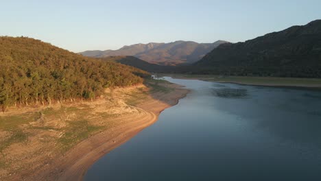 Aerial-drone-footage-following-the-shoreline-of-a-beautiful-lake-between-a-picturesque-mountain-valley-of-northern-Spain