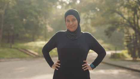 a woman in hijab exercising in the park