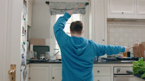 happy-teenage-boy-with-down-syndrome-dancing-in-kitchen-having-fun-celebrating-funny-dance-enjoying-weekend-at-home