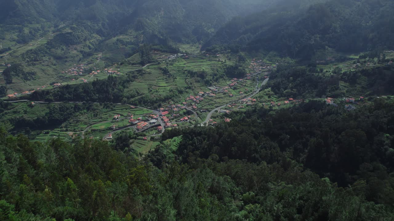 Aerial View of a Mountain Valley with Terraced Fields and Village
