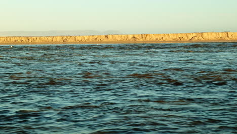 Strong-flow-of-river-water-after-breaching-of-river-mouth-into-ocean,-static