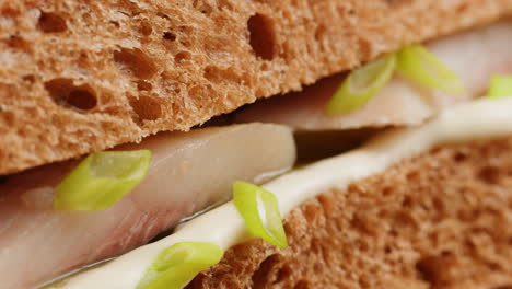 close-up of a sandwich with fish filling and vegetables